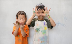 zwei Jungs zeigen Flecken auf Händen und Kleidern nach dem Malen