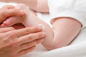 mutter cremt ihr baby mit einer antimykotischen salbe ein