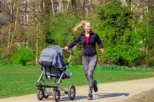 Mutter joggt mit Kinderwagen