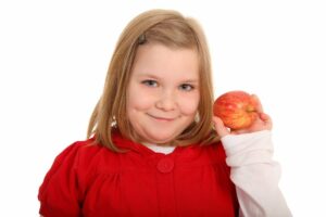 übergewichtiges Kind präsentiert einen Apfel