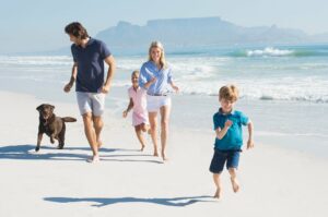 Familie mit Hund am Strand.
