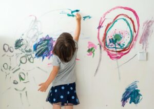 Kleines Mädchen malt an die Wand