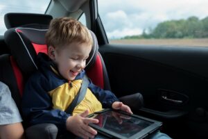 Kind spielt im Auto am Tablet
