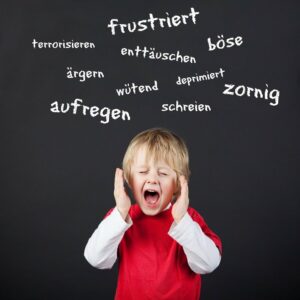 schreiendes Kind vor einer Tafel mit negativ besetzten Begriffen