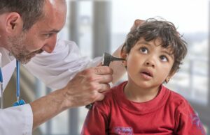 Arzt untersucht die Ohren eines kleinen Jungen auf eine Sprachentwicklungsverzögerung